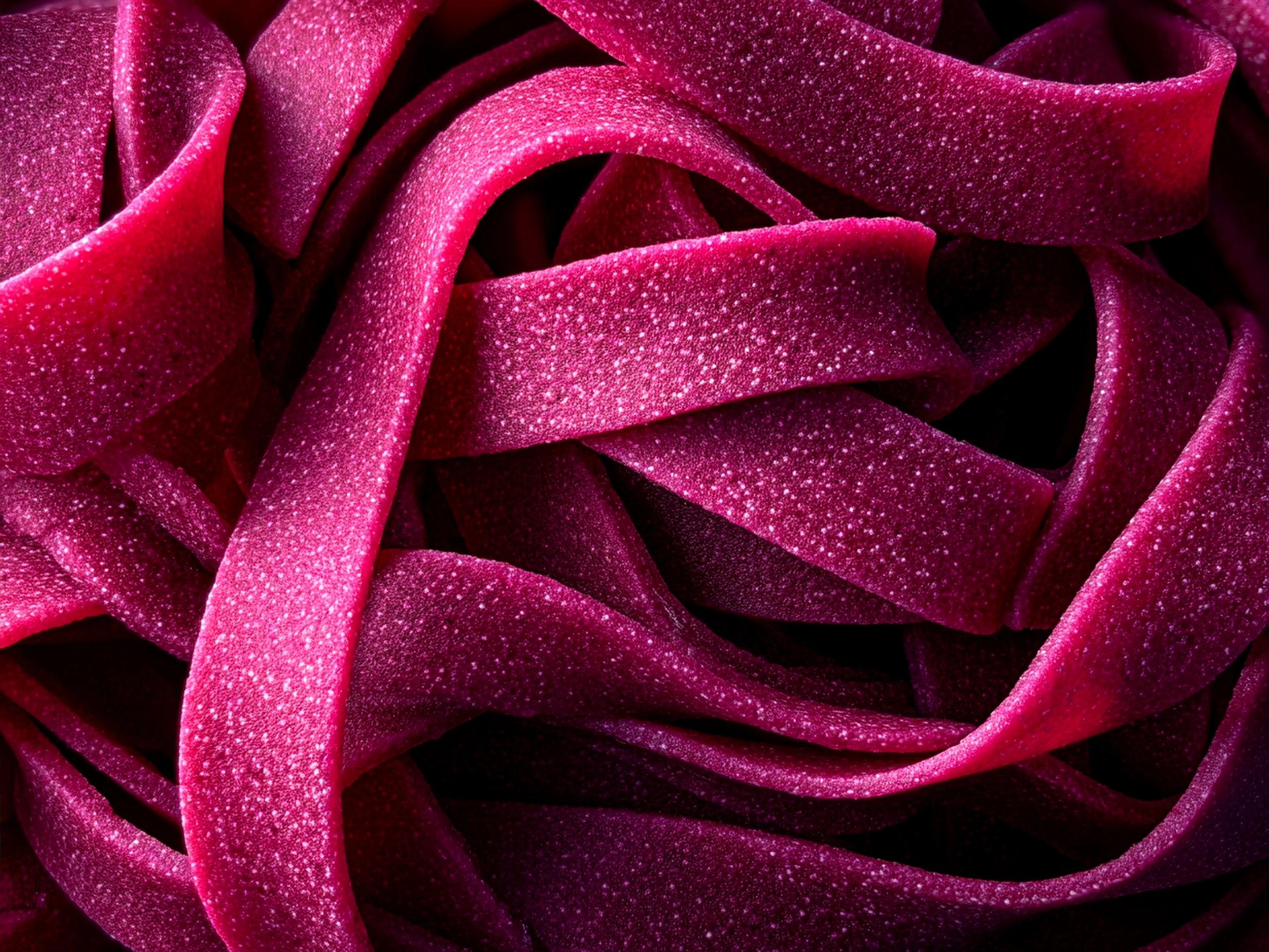 Bright pink Beet Pasta served with creamy sauce, garnished with nuts and basil